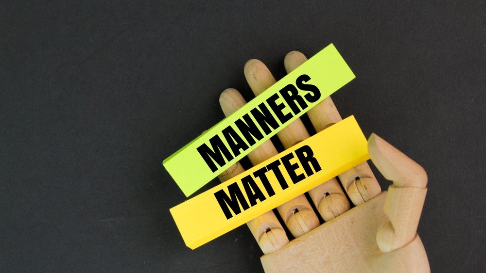 wooden hand and colored paper with the word manners matter