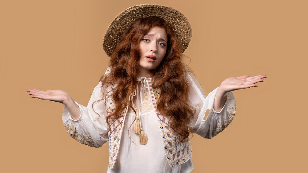 Confused stylish 20s aged woman, shoulders up - can't help, makes gesture of I dont know. Difficult question, guilty reaction, puzzled stylish woman on beige background. High quality