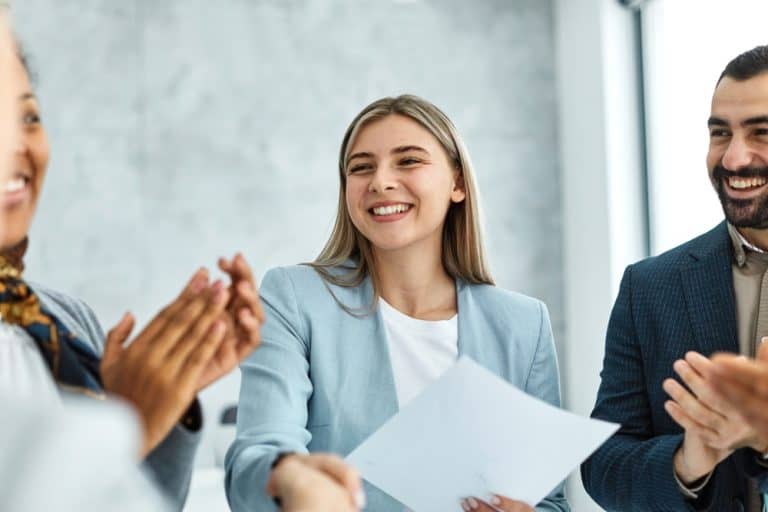 Portrait of a young beautiful businesswoman and businessman shaking hands introducing each other in the office