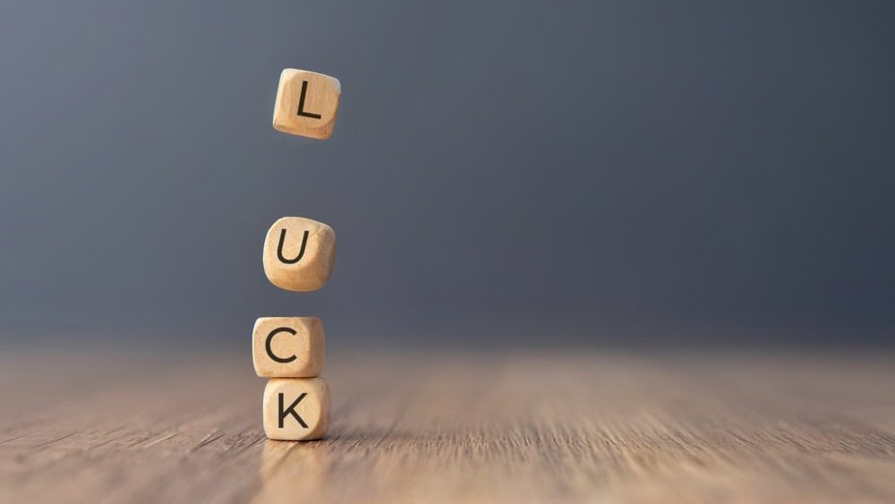 One block with the letter "L" is falling down towards the others. Copy space for text. Luck concept.