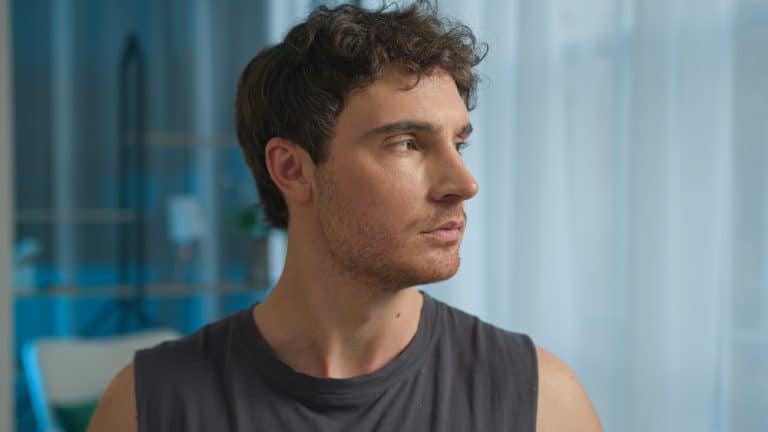 Serious Caucasian man turn head looking at camera confident sportsman sporty male home athlete expression training strong muscular power active lifestyle handsome guy face workout healthy bodybuilder