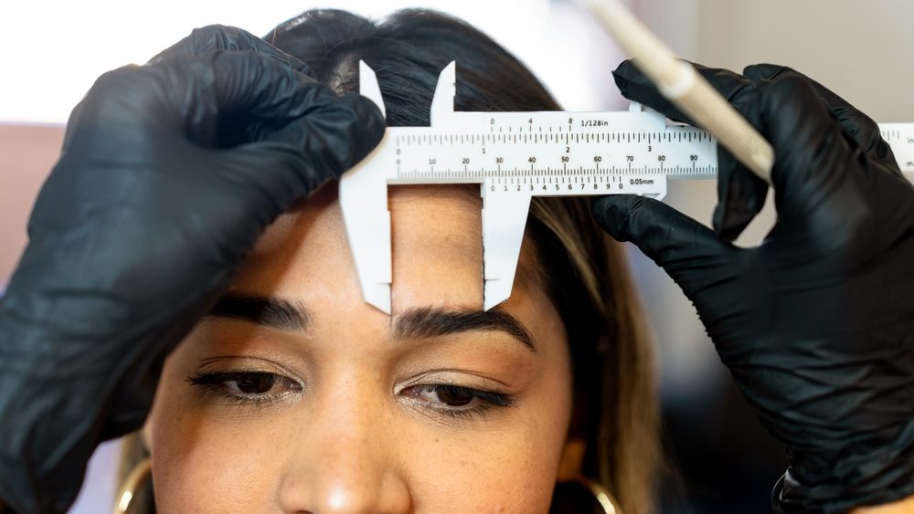 Professional eyebrow beautician. Professional eyebrow measurement in a beauty clinic.