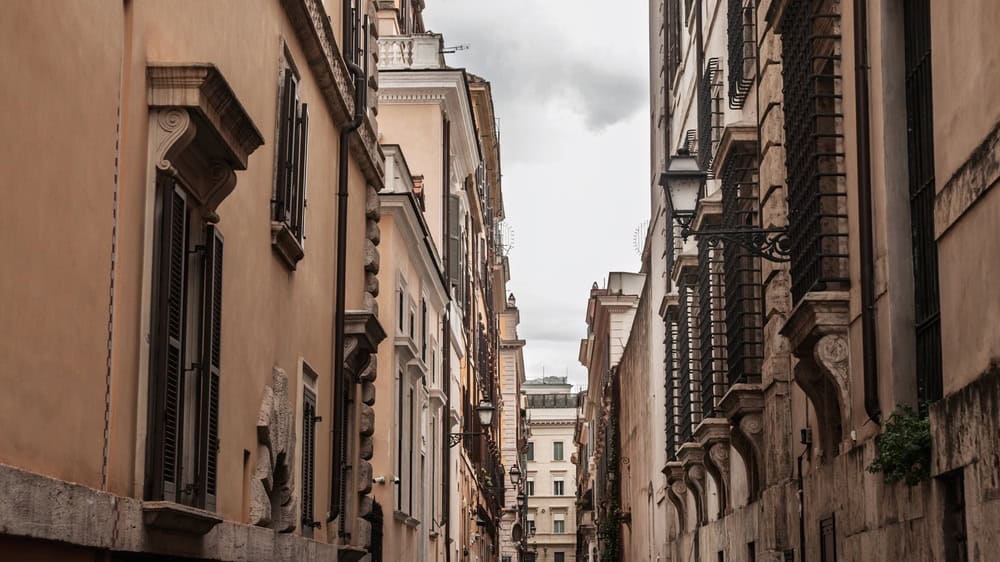 Narrow historic street in the center of Rome, lined with traditional Italian residential architecture, indicative of old Roman property in the old rome, the capital city of italy.