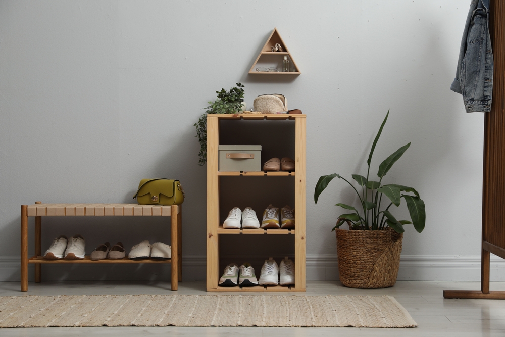 Different footwear on shelves in entryway. Shoe storage