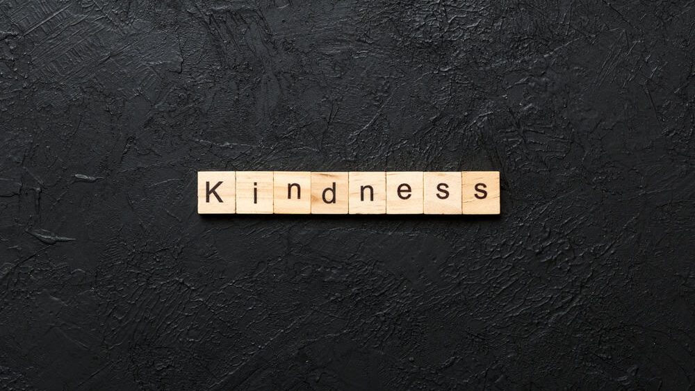kindness word written on wood block. kindness text on table, concept.
