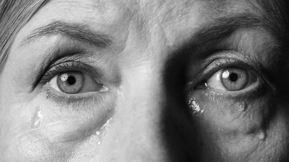 Closeup view of senior woman crying. Black and white effect