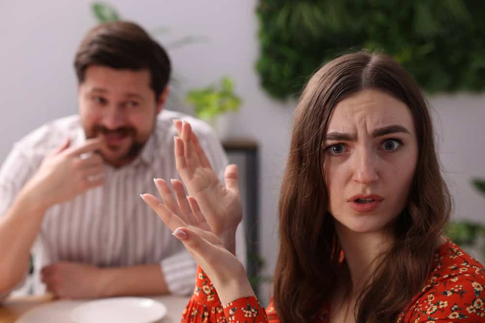 Bad date. Embarrassed woman ignoring flirting man at table during dinner indoors, selective focus