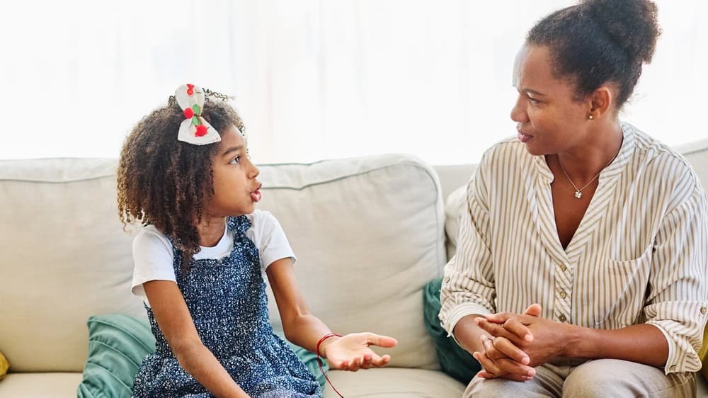 Mother with her teenage daughter at meeting with social worker, psychologist discussing mental health family sitting on sofa in psychotherapist office