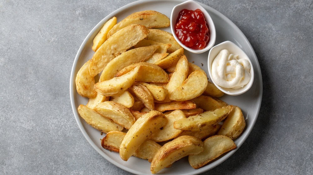 Crispy Golden Potato Wedges Served on a White Ceramic Plate