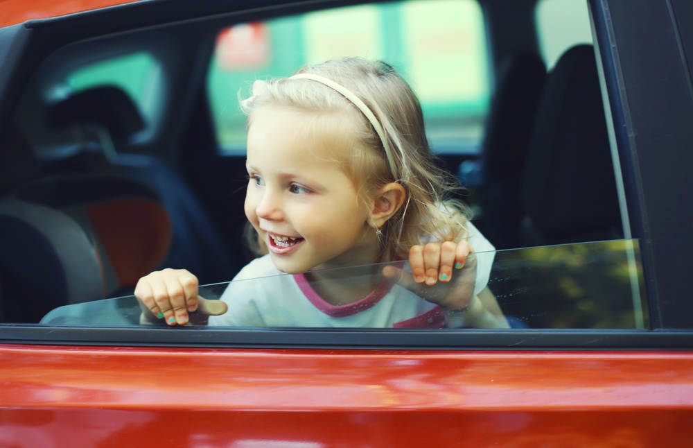 Portrait of happy smiling little girl child passenger sitting in the car