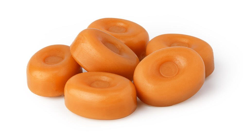 Group of delicious butterscotch candies on a white background