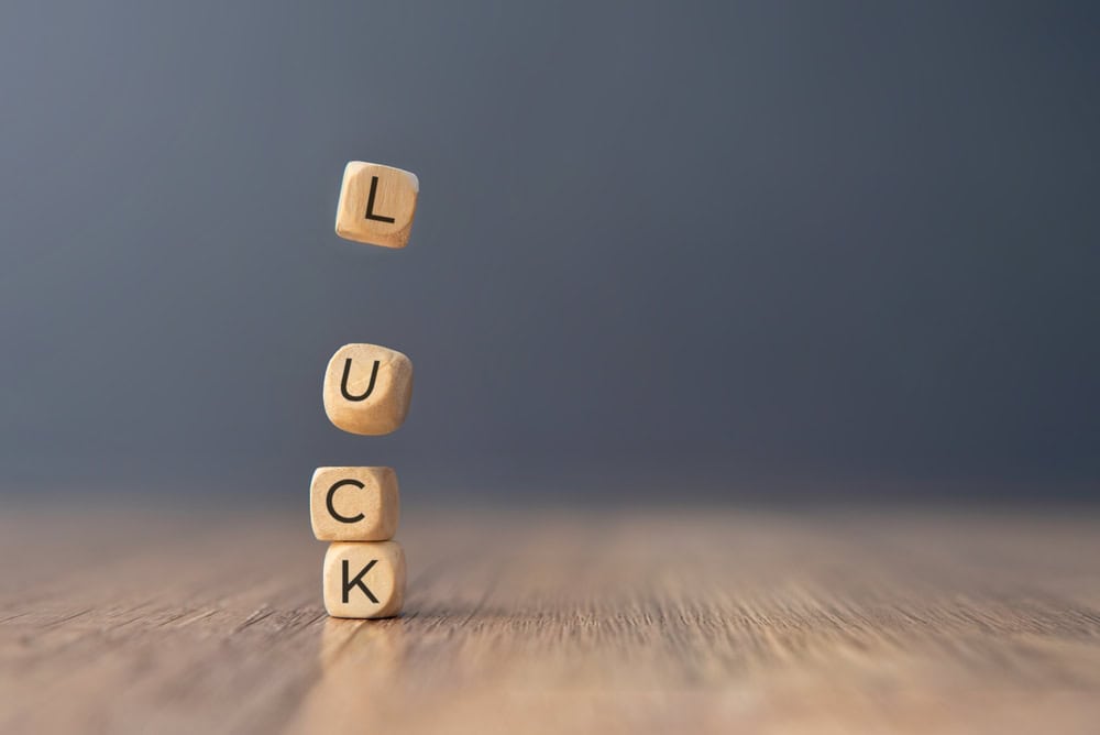 One block with the letter "L" is falling down towards the others. Copy space for text. Luck concept.
