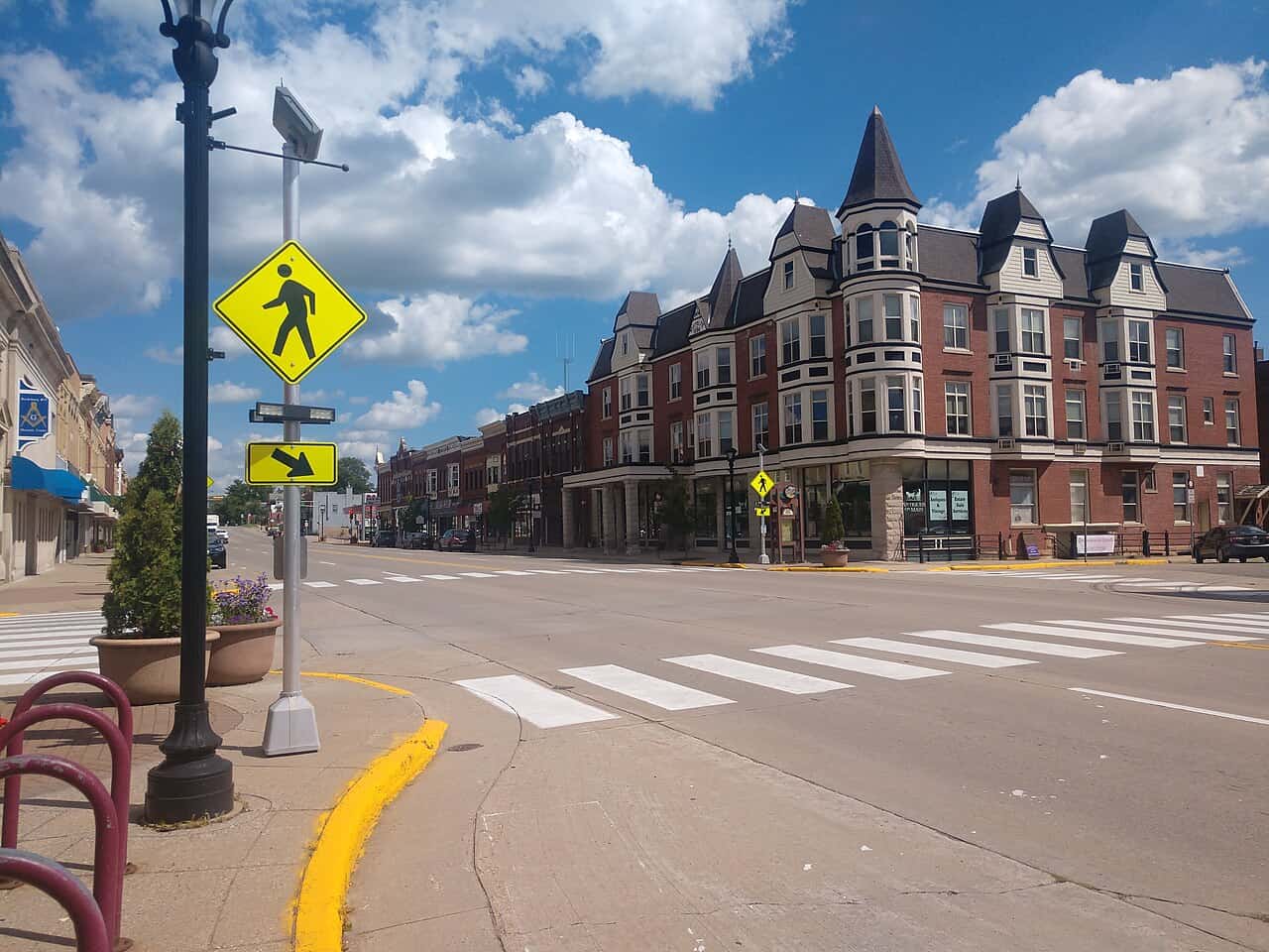 Main Street in Reedsburg, Wisconsin, showing brick buildings and storefronts along a street intersection