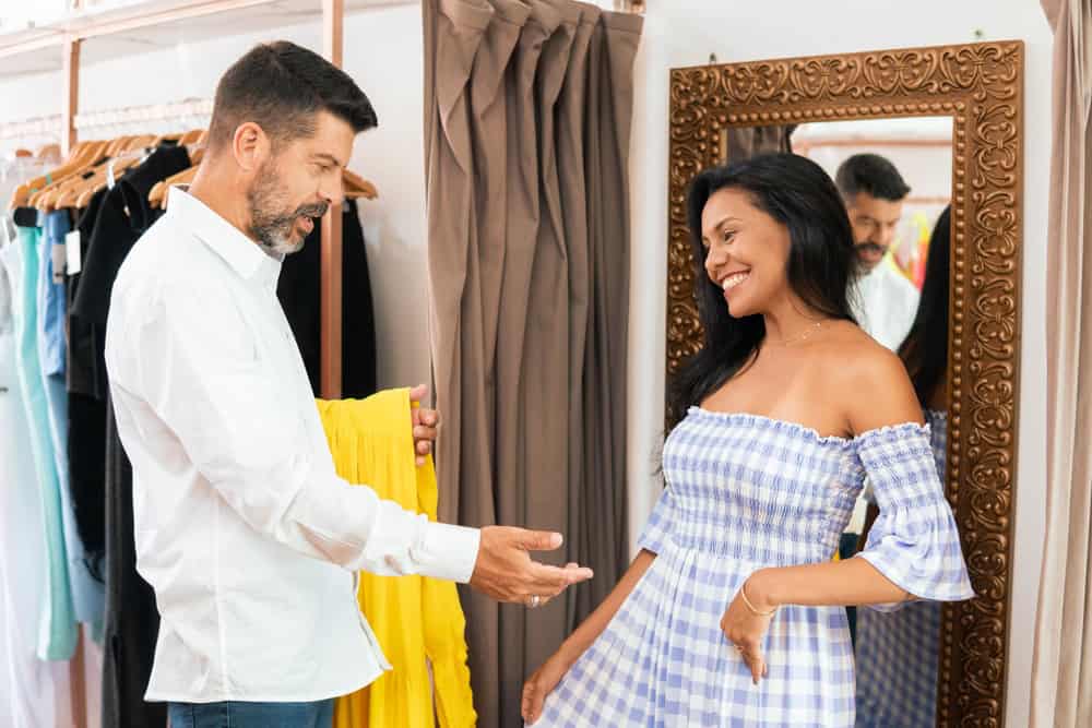 Brazilian man approves customer's dress at a neighborhood store