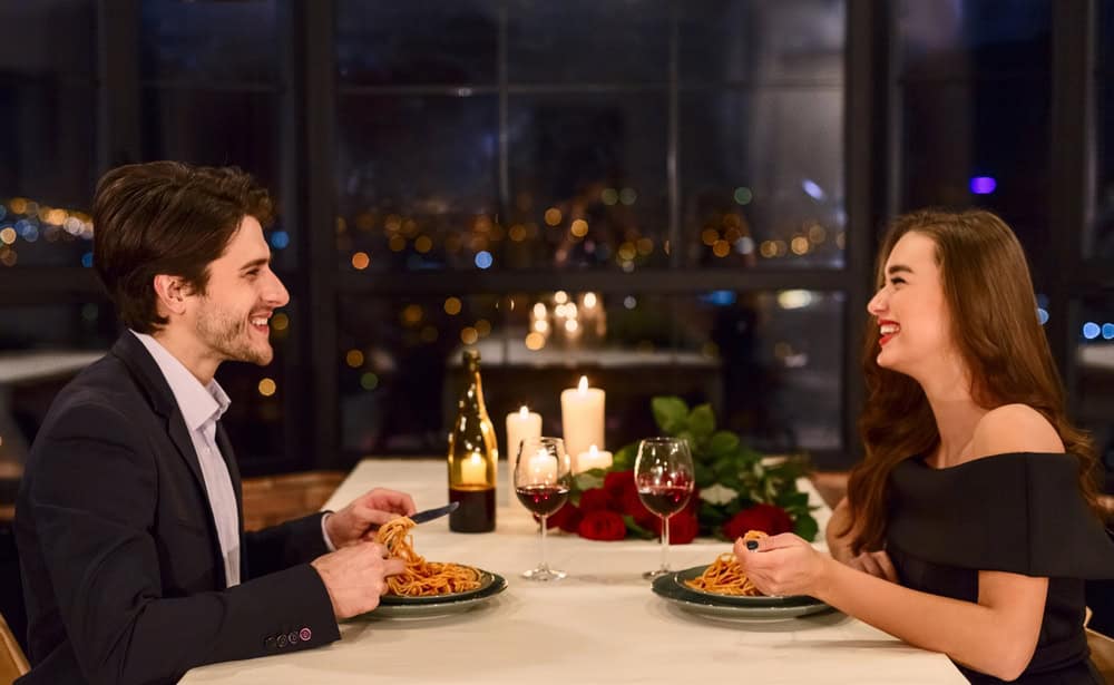 Loving beautiful young couple in a restaurant celebrating anniversary. Romantic dinner on Valentine