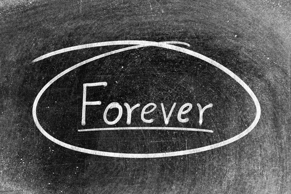White chalk hand writing in word forever and circle shape on blackboard background