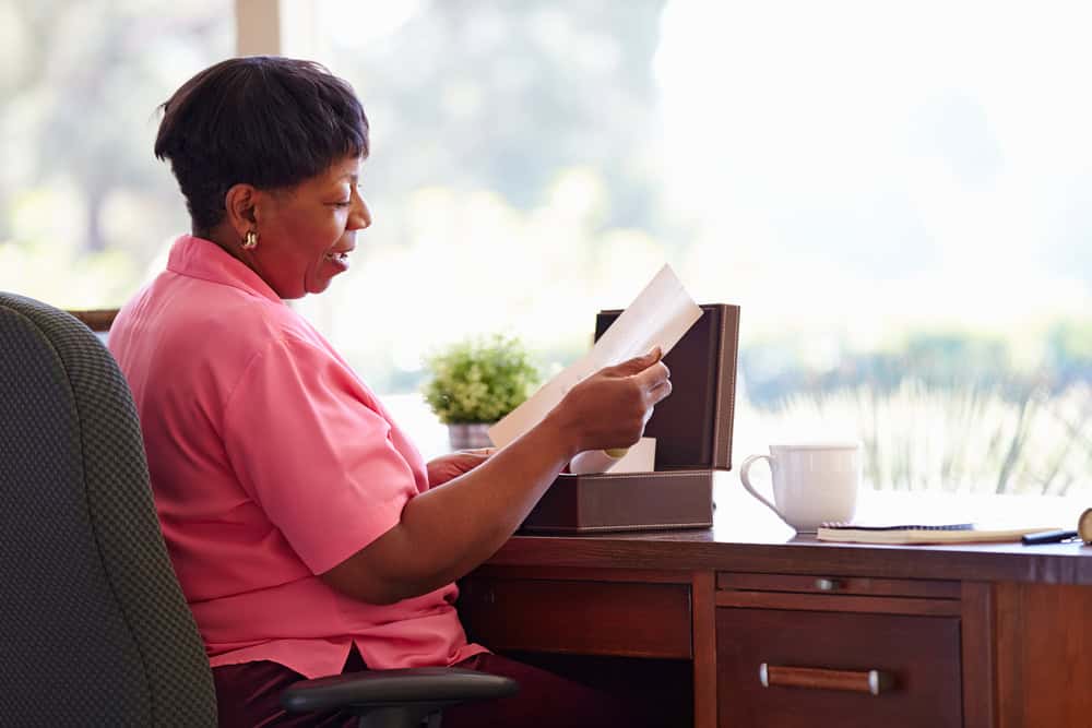 Mature woman putting letter into keepsake box