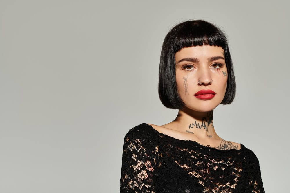 A young woman exudes confidence in trendy attire, showcasing her tattoos.