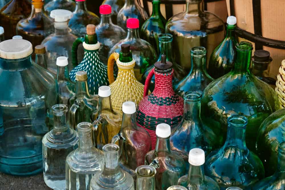 Lots of glass bottles and jugs for pouring homemade wine. Georgian winemaking traditions. Selective focus.