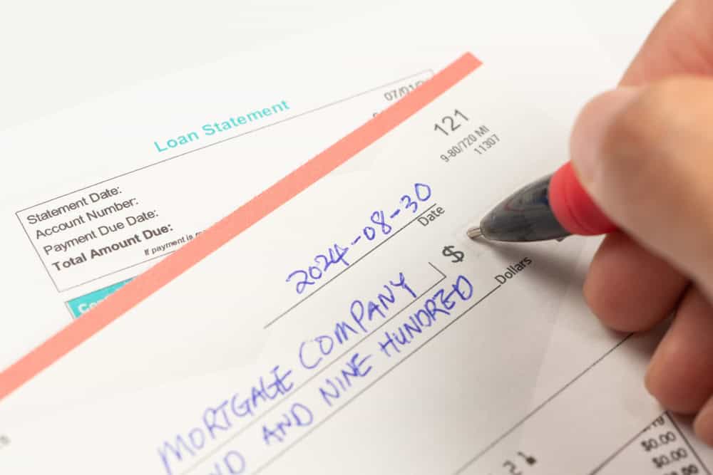 Hand writing a check for a home loan mortgage payment
