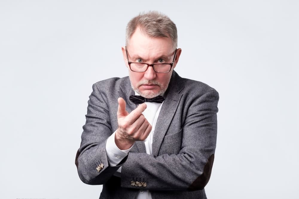 Angry senior man standing and looking at camera and accusing.