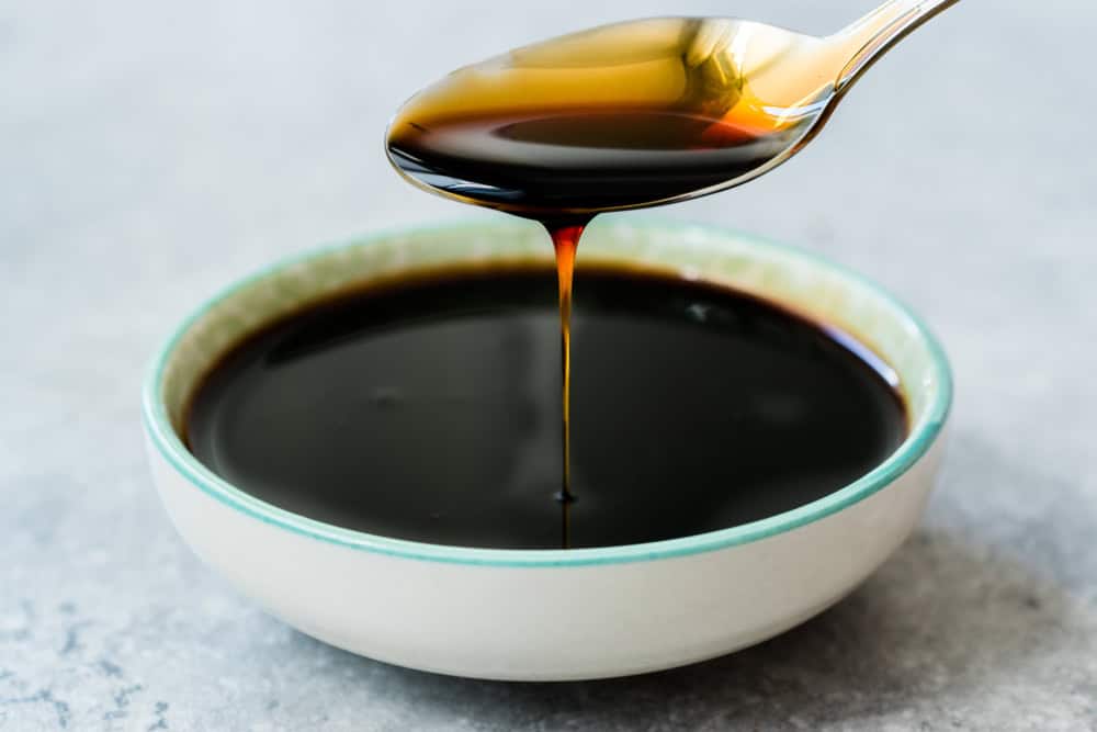 Organic Black Cane Sugar Molasses Dripping from Spoon. Organic Food.