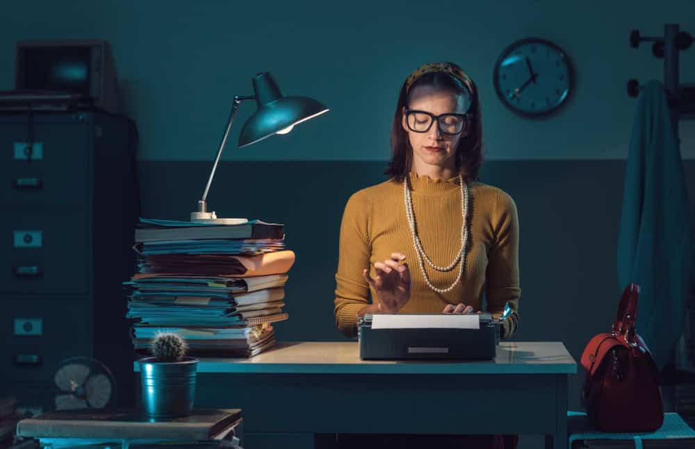 Efficient vintage style secretary working with a typewriter in the office