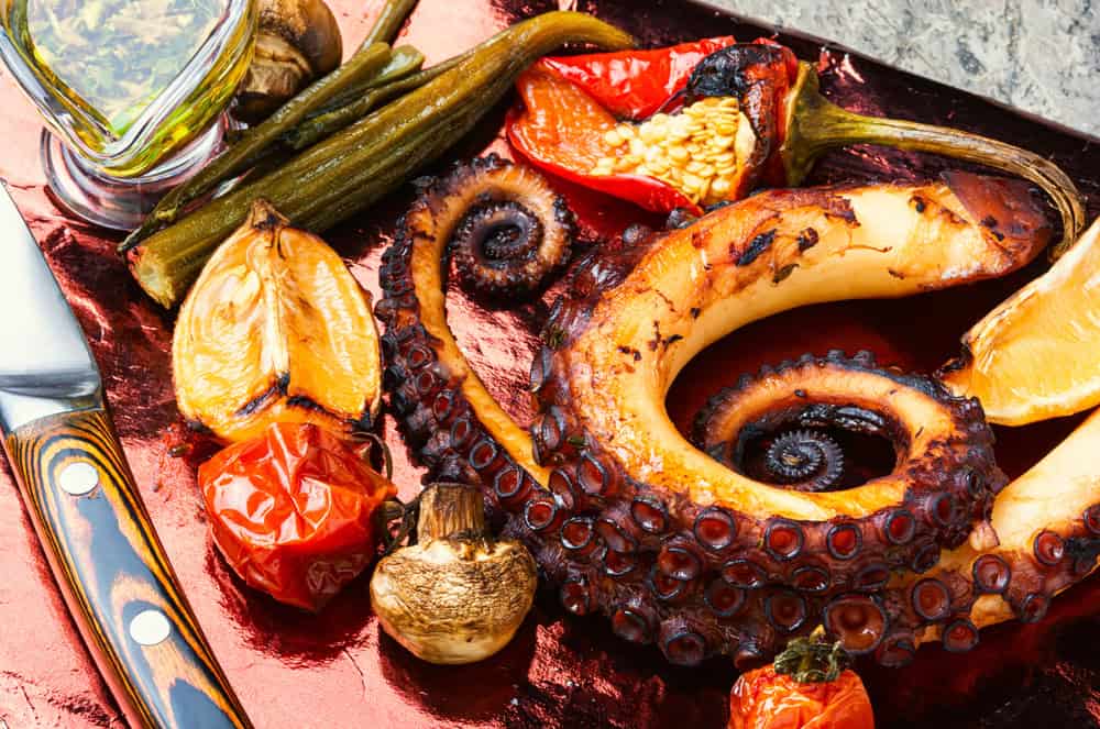 Grilled octopus with roasted vegetables. Octopus tentacles on grill