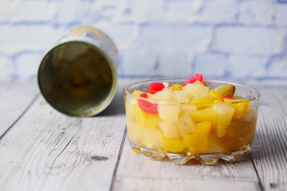 Open can of fruit cocktail on table ,