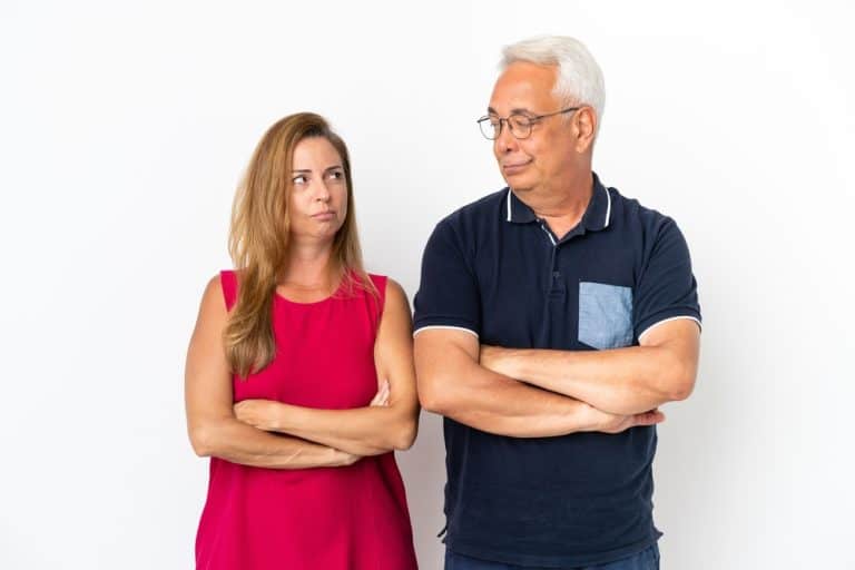 Middle age couple isolated on white background annoyed angry in furious gesture