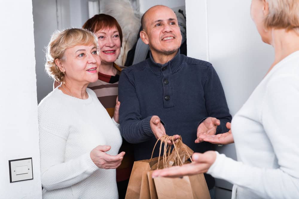Mature friends are talking about their leisure at hallway.