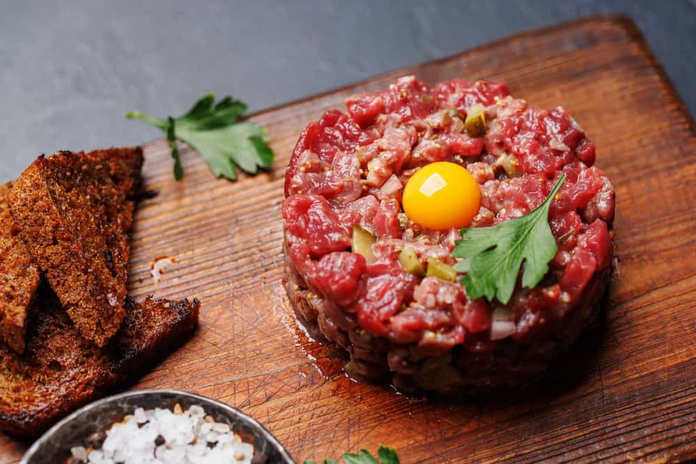 Savory beef tartare with pickled gherkins and brown bread toasts