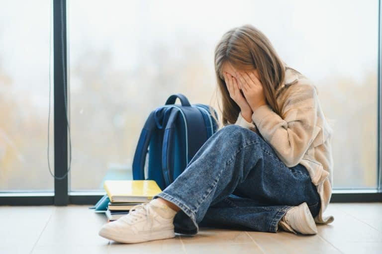 Bullying, discrimination or stress concept. Sad teenager crying in school.