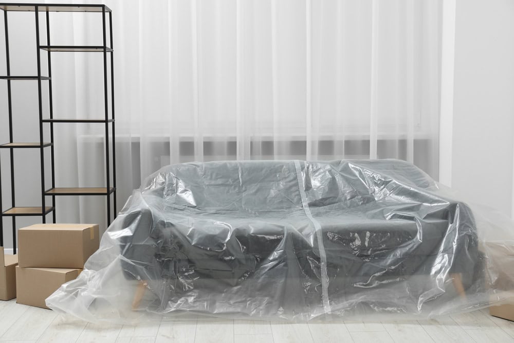 a couch covered in plastic sheet.