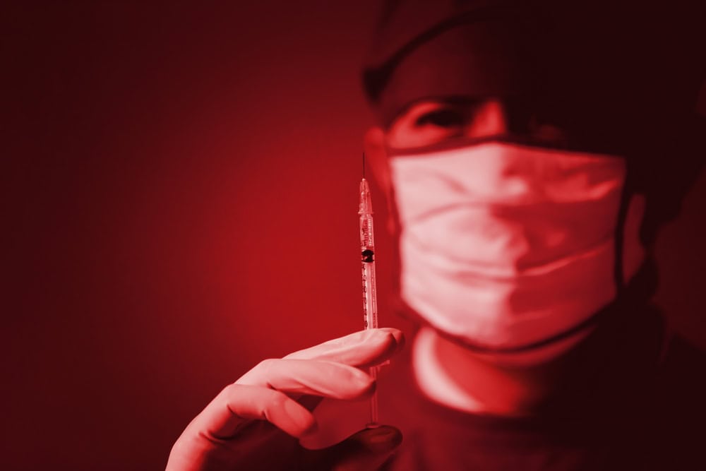 wrong medication drug vaccine abuse silent dying danger kill patient lethal injection in hospital concept. Doctor holding syringe red color tone