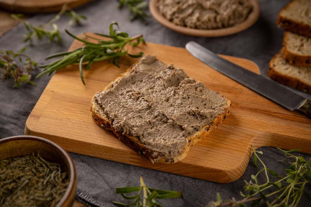 Liver pate spread on toast bread served on wooden board