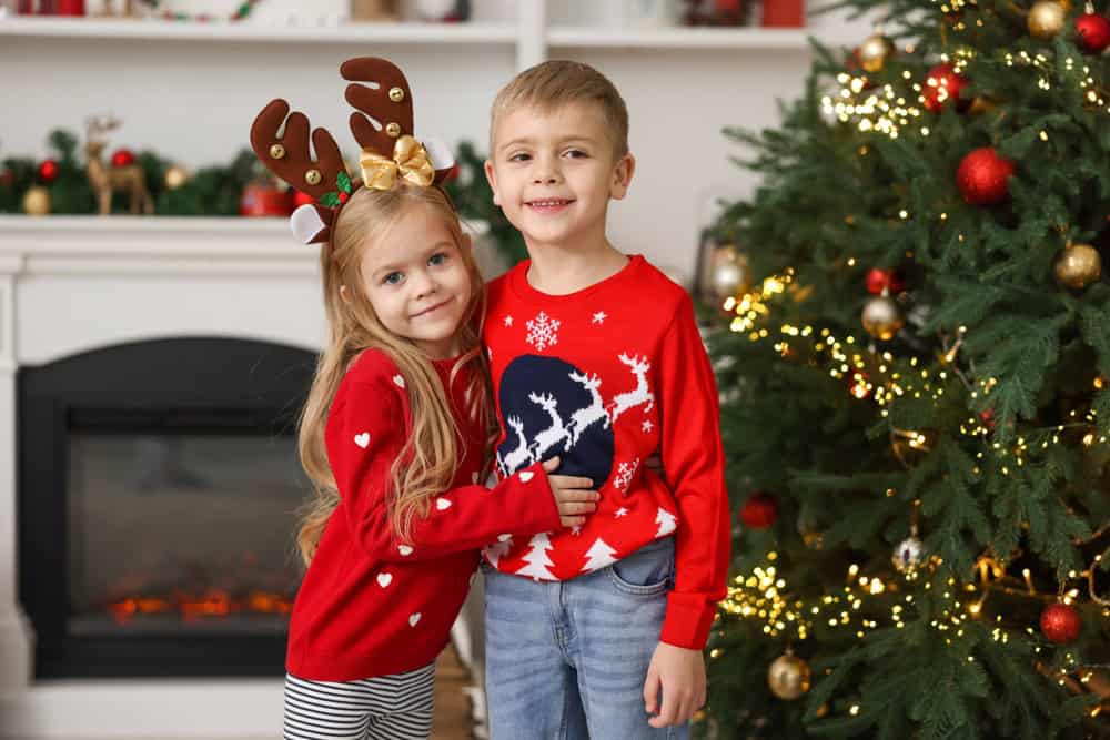 Adorable little kids near Christmas tree at home