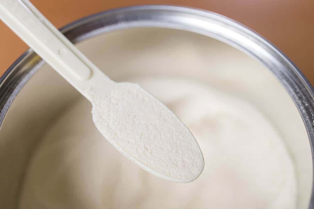 Milk powder scoop placed in metal container