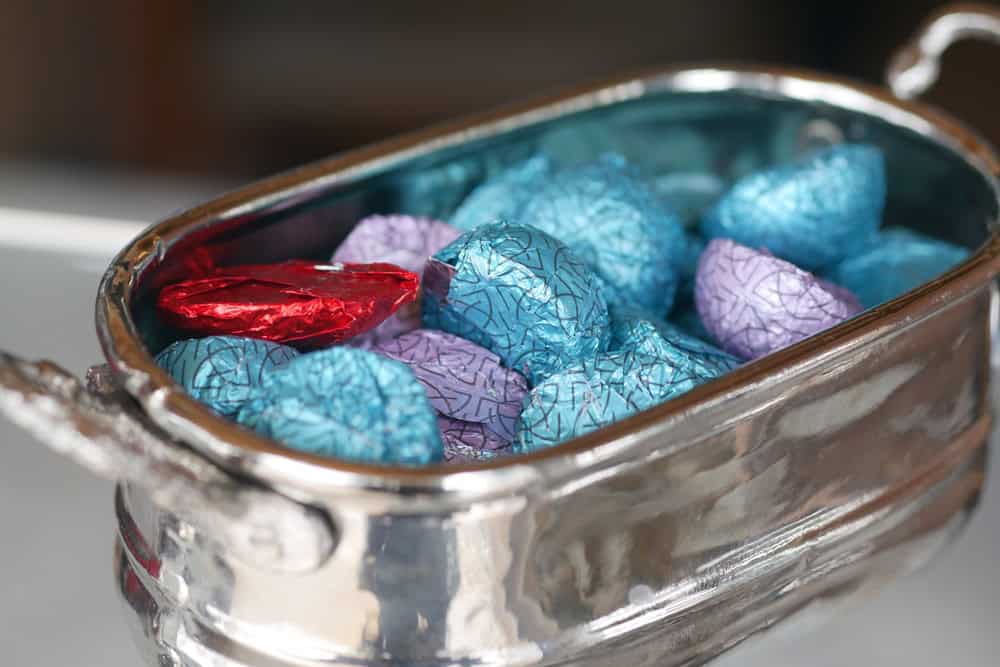Colorful wrapped candies in a silver dish on a table