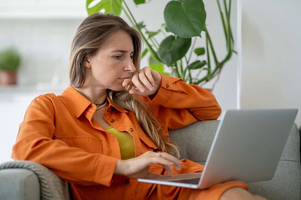 Middle-aged woman intensely focused on laptop carefully researching and studying information online. Female searching causes of emotional exhaustion seeking psychologist for help to overcome burnout