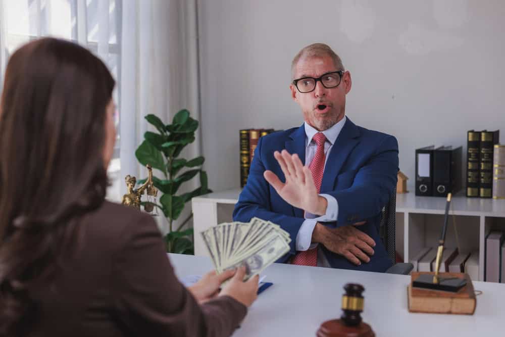 Lawyer rejects money offered by a client, indicating refusal of potential bribery or unethical conduct