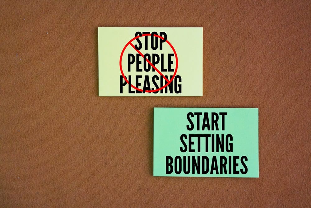 Colored paper with the words STOP PEOPLE PLEASING - START SETTING BOUNDARIES. focus on recognizing your own needs and limits, communicating them clearly