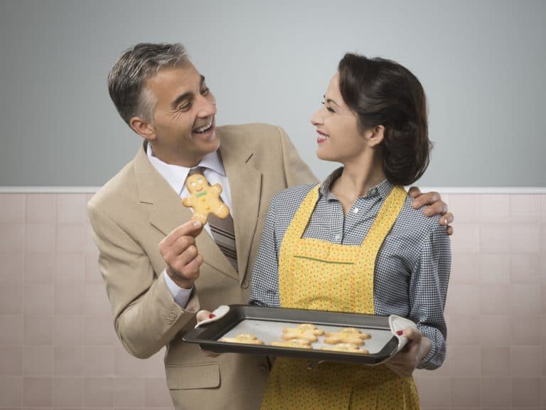 Vintage woman serving home made gingerbread men cookies to her smiling husband