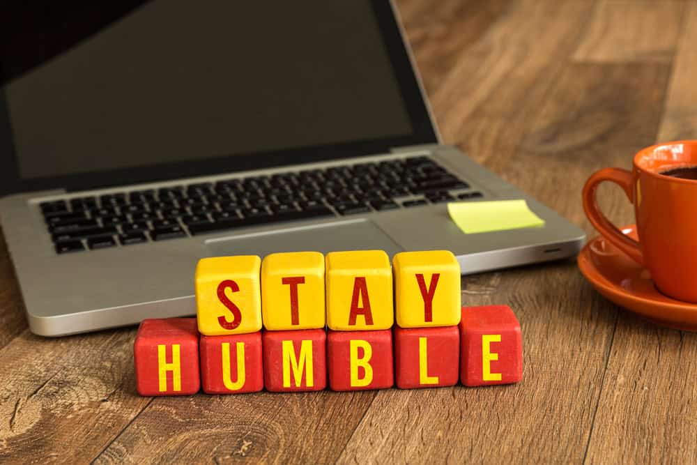 Stay Humble written on a wooden cube in a office desk