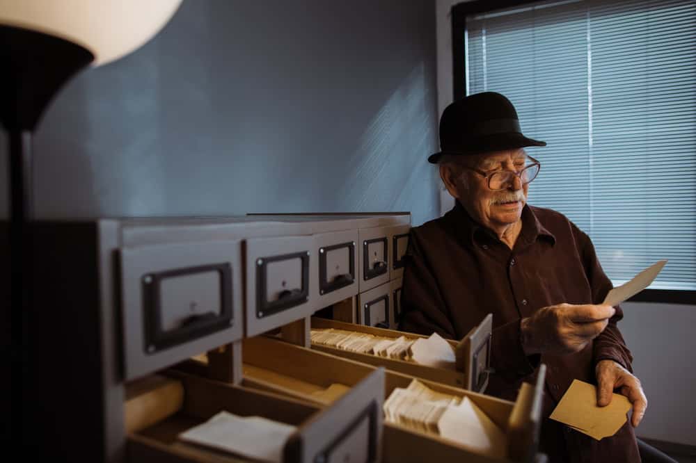 Senior male archivist searching for catalogs