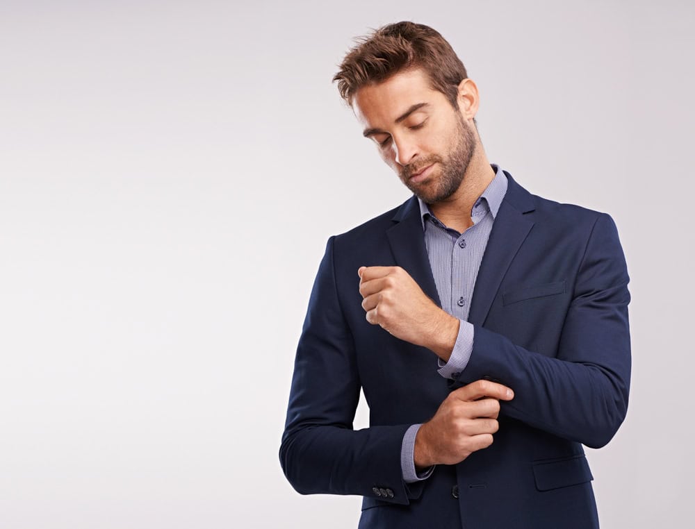 A professional businessman in a suit adjusting his cuff