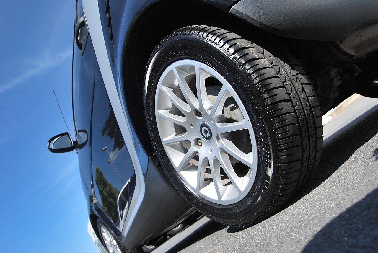 Close-up of a car wheel showing suspension components and tire condition.