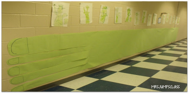 A long, green paper foot hangs on the wall in the hallway