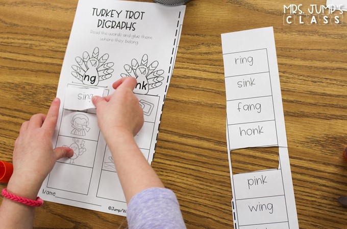 A student is pasting a word onto a word sort worksheet