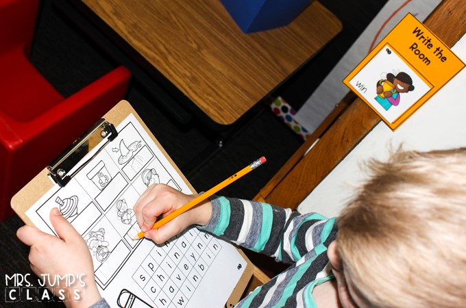 A student is writing a word on a clipboard